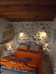 a bedroom with a bed in a stone wall at L'Auberge du Mazet in Lodève