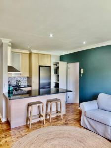 a kitchen and living room with a counter and a couch at The Botanic Venus in Paarl