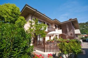 a building with a fence and flowers in front of it at Casa Martinelli in Nago-Torbole
