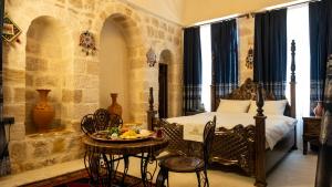 a bedroom with a bed and a table with a plate of food on it at Vezir Konağı Hotel in Mardin