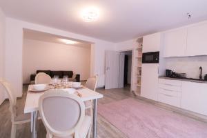 a kitchen and a dining room with a table and chairs at White Valey Retreat One in Buşteni