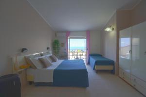 ein Schlafzimmer mit einem großen Bett und einem Balkon in der Unterkunft Hotel Orizzonte Blu in Tropea + 79 Fotos