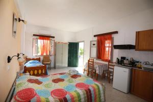 a bedroom with a bed and a kitchen with a kitchen at Katina Balos Rooms-Studios in Koumeika