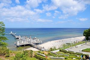 a view of a beach with a pier and the ocean at Ferienhaus unterm Reetdach in Ostseebad Sellin