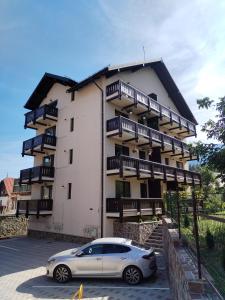 a car parked in front of a building at White Valey Retreat One in Buşteni