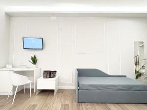 a white bedroom with a bed and a desk at Napoleon in Tropea
