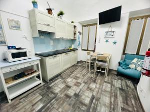 a small kitchen with white cabinets and a blue couch at The Blue Nest Suite - Sanremo in Sanremo