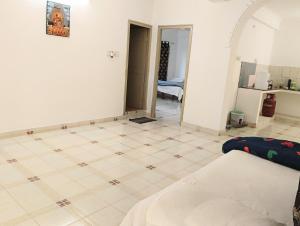 a room with a tile floor and white walls at Chetanya Homestay in Puttaparthi