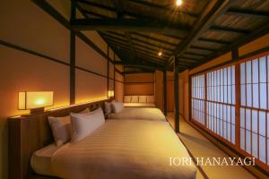a bedroom with two beds in a room with windows at IORI Stay in Takayama