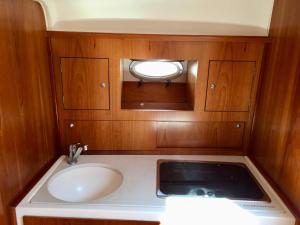 a small bathroom with a sink and a mirror at Palermo Boat Experience in Isola delle Femmine