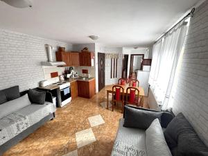 a living room with a couch and a kitchen at Tabán Apartman in Dunakeszi