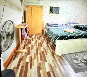 a bedroom with a bed and a fan at Dahlia Roomstay Jelai in Gemas