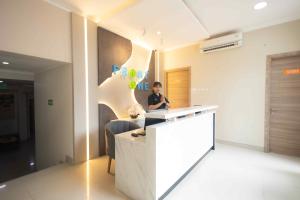 a woman sitting at a counter in a room at Front One Budget Malioboro Jogja in Yogyakarta