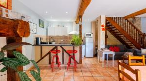 a kitchen and living room with red stools at La Ferme des Grisettes in Montesquiou +36 photos