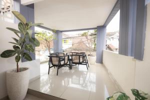 a dining room with a table and chairs and a potted plant at Front One Budget Malioboro Jogja in Yogyakarta