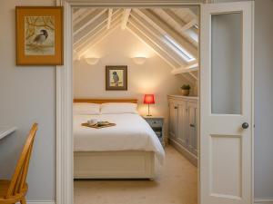 a bedroom with a white bed and a window at The Coach House - Uk50884 in North Walsham