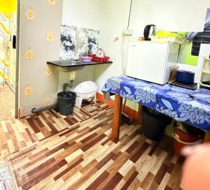 a kitchen with a wooden floor and a table at Dahlia Roomstay Jelai in Gemas