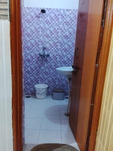 a small bathroom with a sink and a toilet at Esadan in Agra