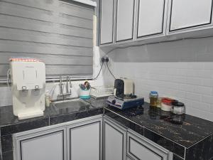 a kitchen counter with a sink and a mixer at Homestay Una Kangar in Kangar +6 photos