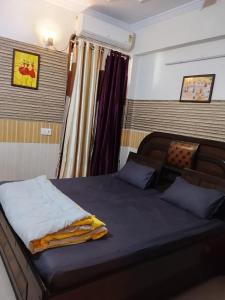 a bedroom with a bed with blue sheets at Esadan in Agra
