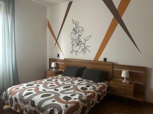 a bedroom with a bed with a flower painting on the wall at Lake Garda in Gavardo