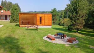 a cabin in a yard with a table and benches at Motýlek chata Sedmička in Borušov