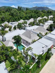 an aerial view of a white house with trees at Anchan Flora by Villacarte in Ban Phru Champa