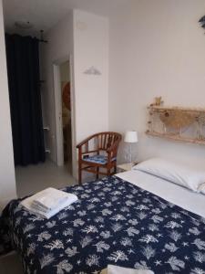 a bedroom with a bed with a blue and white blanket at La Dea Madre in Stintino