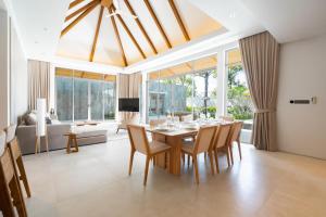a dining room with a table and chairs at Anchan Flora by Villacarte in Ban Phru Champa