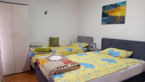 a bedroom with two beds and a painting on the wall at Apartmani Lucky in Vrnjačka Banja