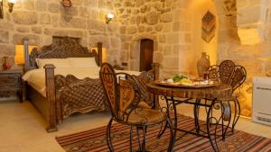 a bedroom with a bed and a table and chairs at Vezir Konağı Hotel in Mardin +68 photos
