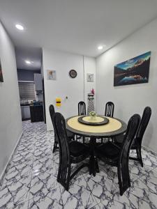 a dining room with a table and black chairs at Homestay Una Kangar in Kangar