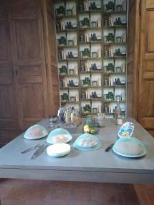 a table with plates and utensils on it at Les feuillets de la Buire in Monteux