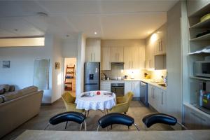 a kitchen with a table and chairs in a room at Windsong Living - Eagle Owl in Krugersdorp