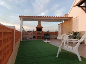 a patio with a gazebo and a green lawn at Lar Dos Guerreiros in Vila Nova de Milfontes