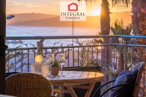 a table with wine glasses on a balcony with a view of the ocean at Les Palmeres Palamós in Palamós