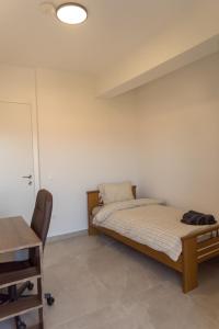 two beds in a room with a table and a desk at Signature city loft in Tríkala