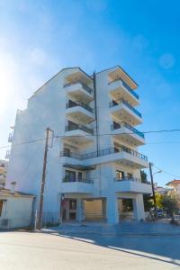 a white building with balconies on the side of it at Signature city loft in Tríkala