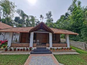 a home with a brick house with a porch at Whispering Meadows By Dazzle Destinations - Coorg in Somvārpet