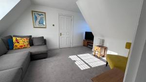 a living room with a couch and a tv at The Coach House WPH, Epping in Epping