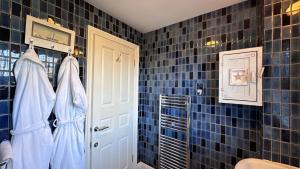 a bathroom with blue tiled walls and a white door at The Coach House WPH, Epping in Epping +50 photos