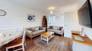 a living room with a couch and a table at Life of Filey - Part of the The Bay Filey Holiday Village with pool, gym and direct beach access, pub, restaurant, tennis and meadows walks in Reighton