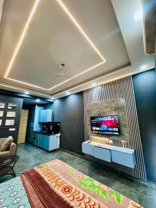 a living room with a large bed and a flat screen tv at Unique property in Ghaziabad