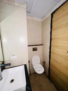 a small bathroom with a toilet and a sink at Unique property in Ghaziabad +3 photos