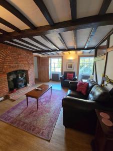 a living room with a leather couch and a fireplace at Stunning 1 bedroom self contained apartment in Kent