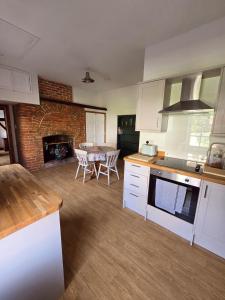 a kitchen with white cabinets and a living room with a table at Stunning 1 bedroom self contained apartment in Kent