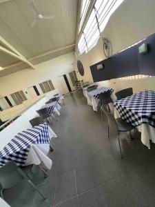 a dining room with blue and white tables and chairs at Suite de hotel dentro centro comercial in Cartago