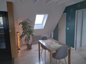 a dining room with a table and a plant at Le repos du facteur in Riquewihr