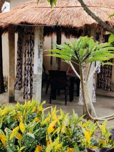 a hut with a table and a palm tree at Rapti Resort in Jhawāni