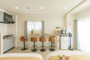 a kitchen with a counter and two stools in a room at night-night 東京ドーム便利 江戸川橋駅近 池袋銀座直通 商店街徒歩圏内 in Tokyo